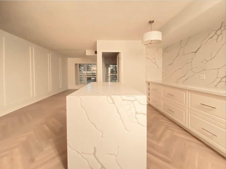 after condo renovation quartz waterfall island counter backsplash herringbone floor picture frame wall moulding remove wall the esplanade old toronto adept services