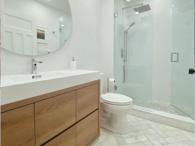 bathroom renovation marble herringbone floor tile toronto vanity butternut bliss vanity rain shower round mirror extended Adept Services Contractor GTA Toronto